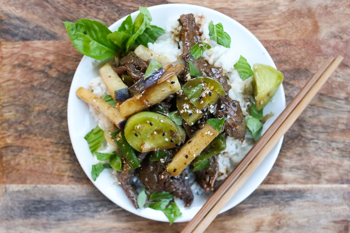 A restaurant-quality meal in 30 minutes, this Green Tomato and Beef Stir Fry uses tender beef, green tomatoes, Kohlrabi (a healthy root vegetable), Shishito peppers, and onions in a savory brown sauce and topped with tuxedo sesame seeds and fresh basil.